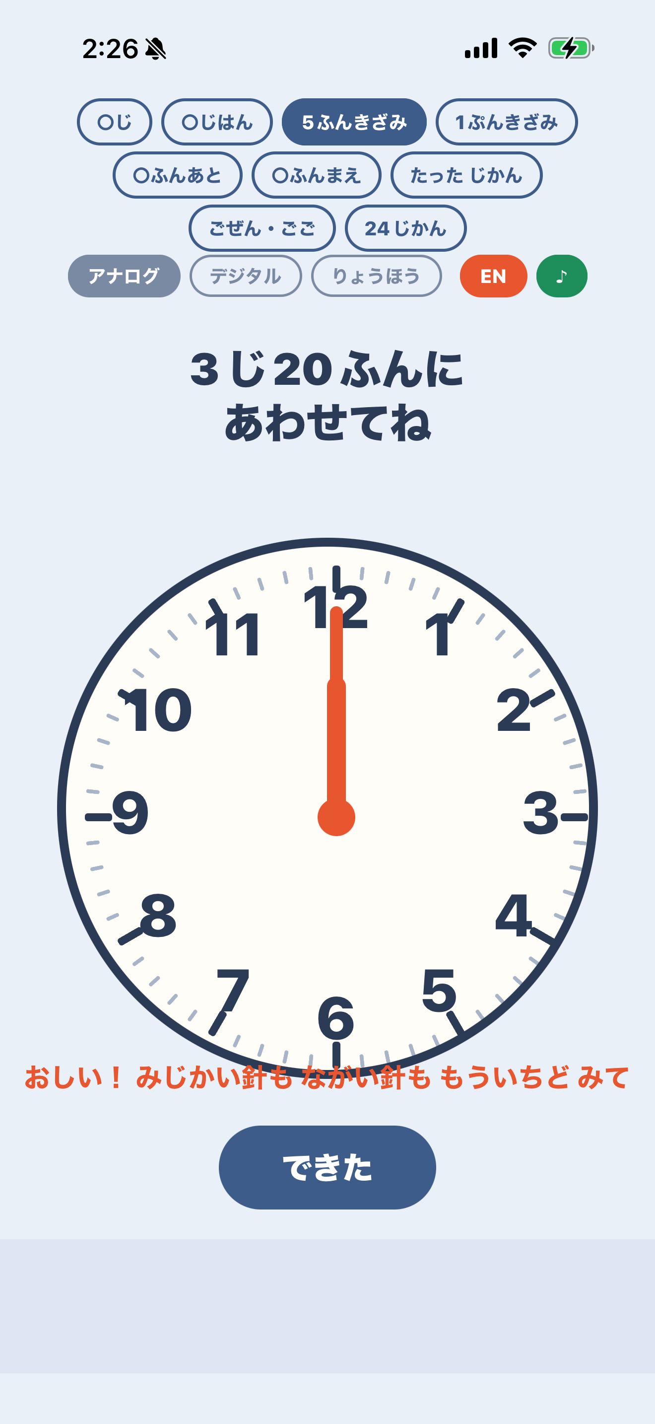 アナログモードの画面。大きな文字盤の下端に、オレンジ色のヒント文「おしい！ みじかい針も ながい針も もういちど みて」が重なり、数字の6や5と交差している